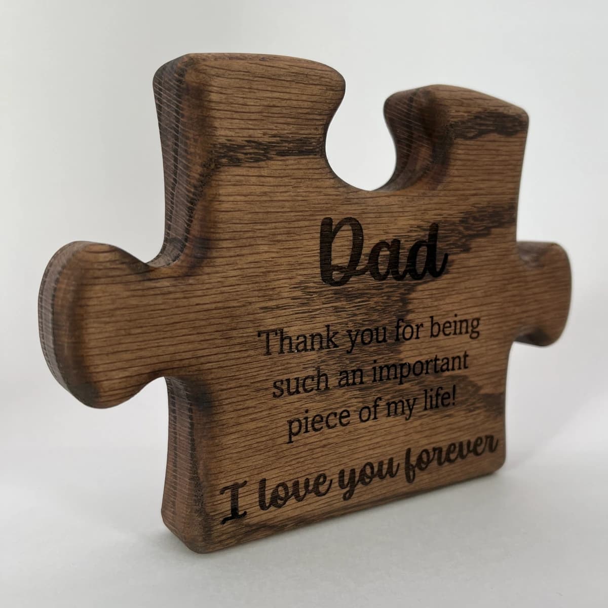 Engraved red oak wood puzzle piece with a father's day message engraved on the front.