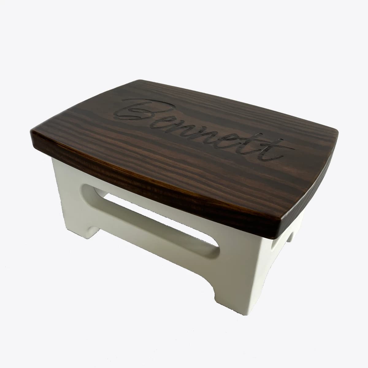 A wooden step stool for a child with the name "Bennett" engraved on the top.