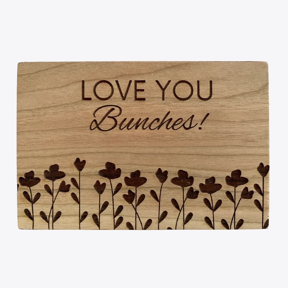 Wooden card with the phrase "Love you bunches!" and some decorative flowers engraved.