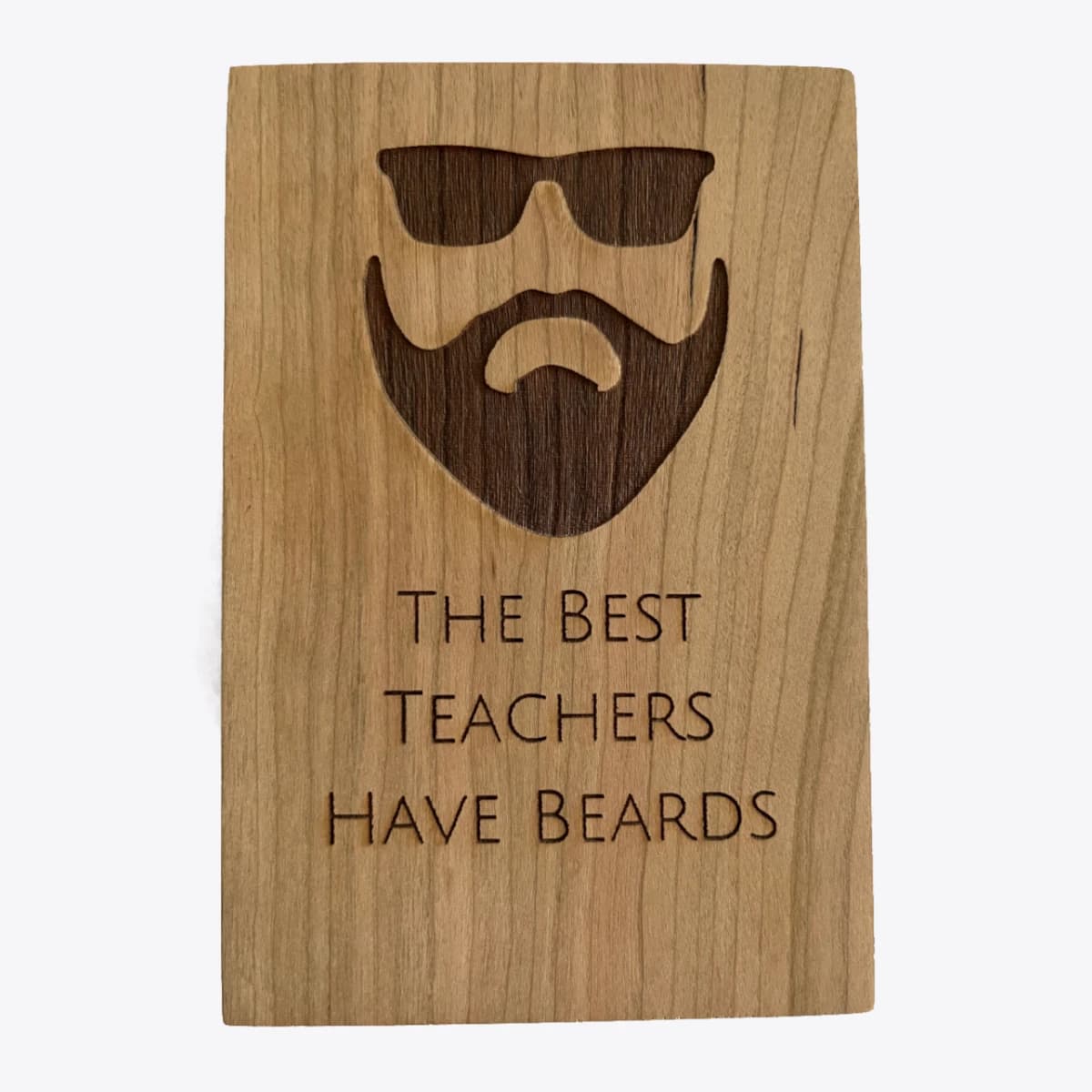 A wooden card that is laser engraved with an image of a man with a beard and text that says the best teachers have beards.